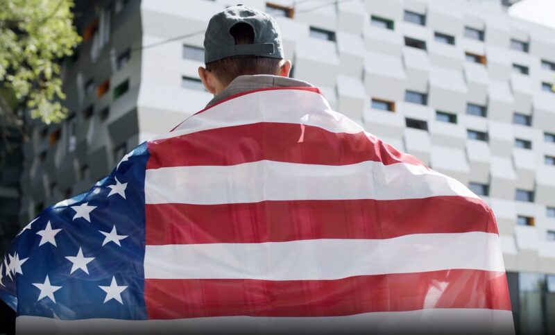 man holding us flag on protest