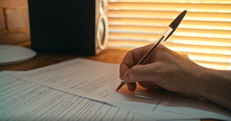 man writing with a pen
